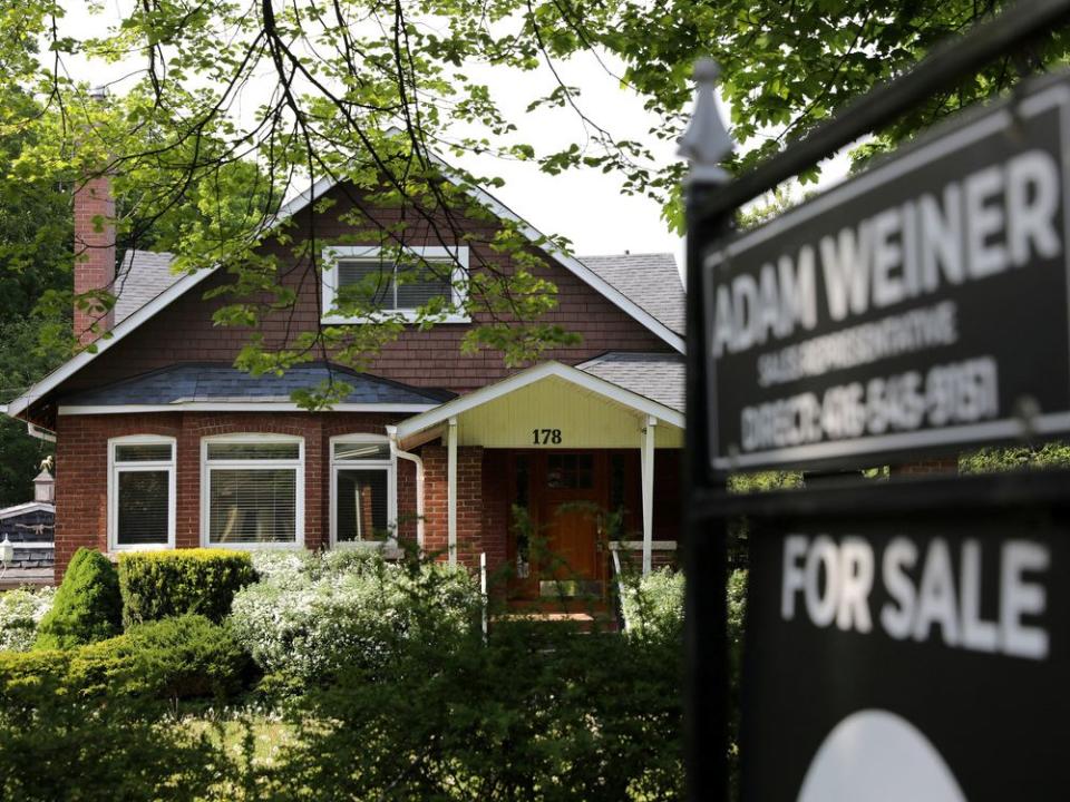 FILE PHOTO: A realtor's sign stands outside a house for sale in Toronto