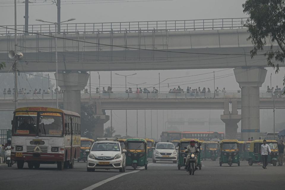 Commuters make their way along a street amid smoggy conditions in New Delhi (AFP/Getty)