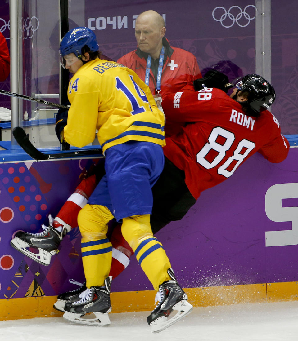 Sweden forward Patrik Berglund collides with Switzerland forward Kevin Romy in the first period of a men's ice hockey game at the 2014 Winter Olympics, Friday, Feb. 14, 2014, in Sochi, Russia. (AP Photo/Julio Cortez)