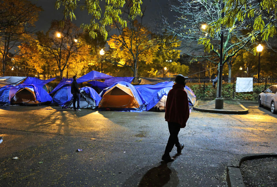 Nathan McCarthy walks through a parking lot outside the 15th District police station, a space he shares with newly arrived migrants in Chicago's Austin neighborhood on Nov. 5, 2023. (Chris Sweda / Chicago Tribune via Getty Images)