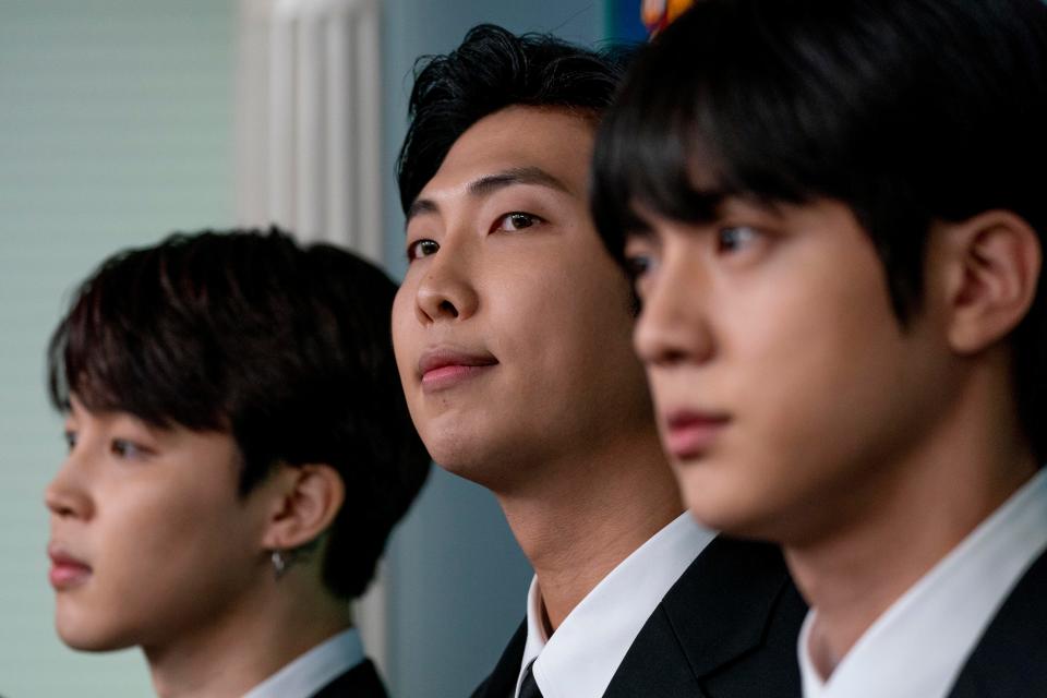 From left, K-pop supergroup BTS members Jimin, RM, and Jin, appear during the daily briefing.