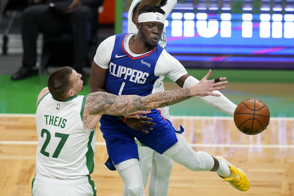 LA Clippers guard Reggie Jackson (1) passes the ball against the defense of Boston Celtics center Daniel Theis (27) in the first quarter of an NBA basketball game, Tuesday, March 2, 2021, in Boston. (AP Photo/Elise Amendola)