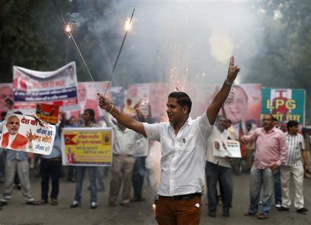 A supporter of India's main opposition Bharatiya Janata Party (BJP) lights firecrackers to celebrate before India's Hindu nationalist Narendra Modi was crowned as the prime ministerial candidate for the BJP outside the party headquarters in New Delhi September 13, 2013. REUTERS/Ahmad Masood