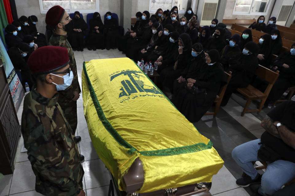 Hezbollah fighters stand in front of the coffin of Ali Atwa, a senior Hezbollah operative, during his funeral procession in the southern Beirut suburb of Dahiyeh, Lebanon, Saturday, Oct. 9, 2021. Atwa was placed on the FBI's most wanted list in 2001, with two other alleged participants in the 1985 hijacking of TWA Flight 847, one of the worst hijackings in aviation history and that lasted for 16 days. (AP Photo/Bilal Hussein)