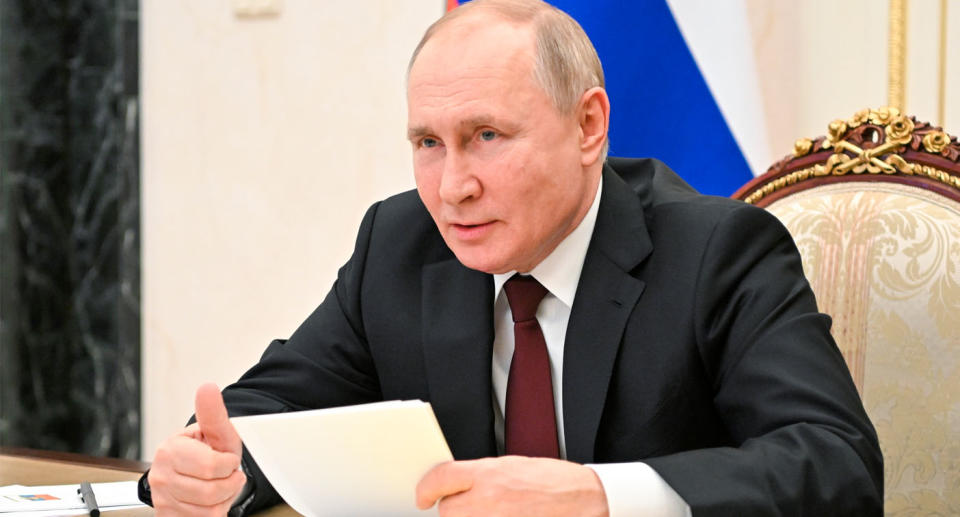 Vladimir Putin sitting at desk with papers