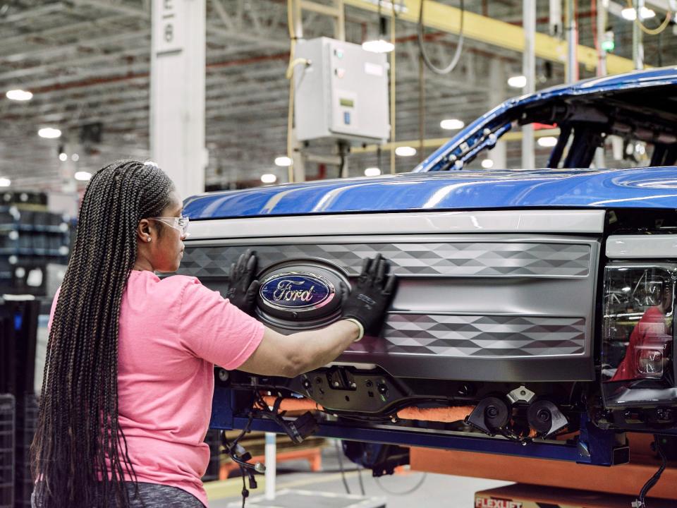 A Ford assembly worker with an electric F-150 Lightning