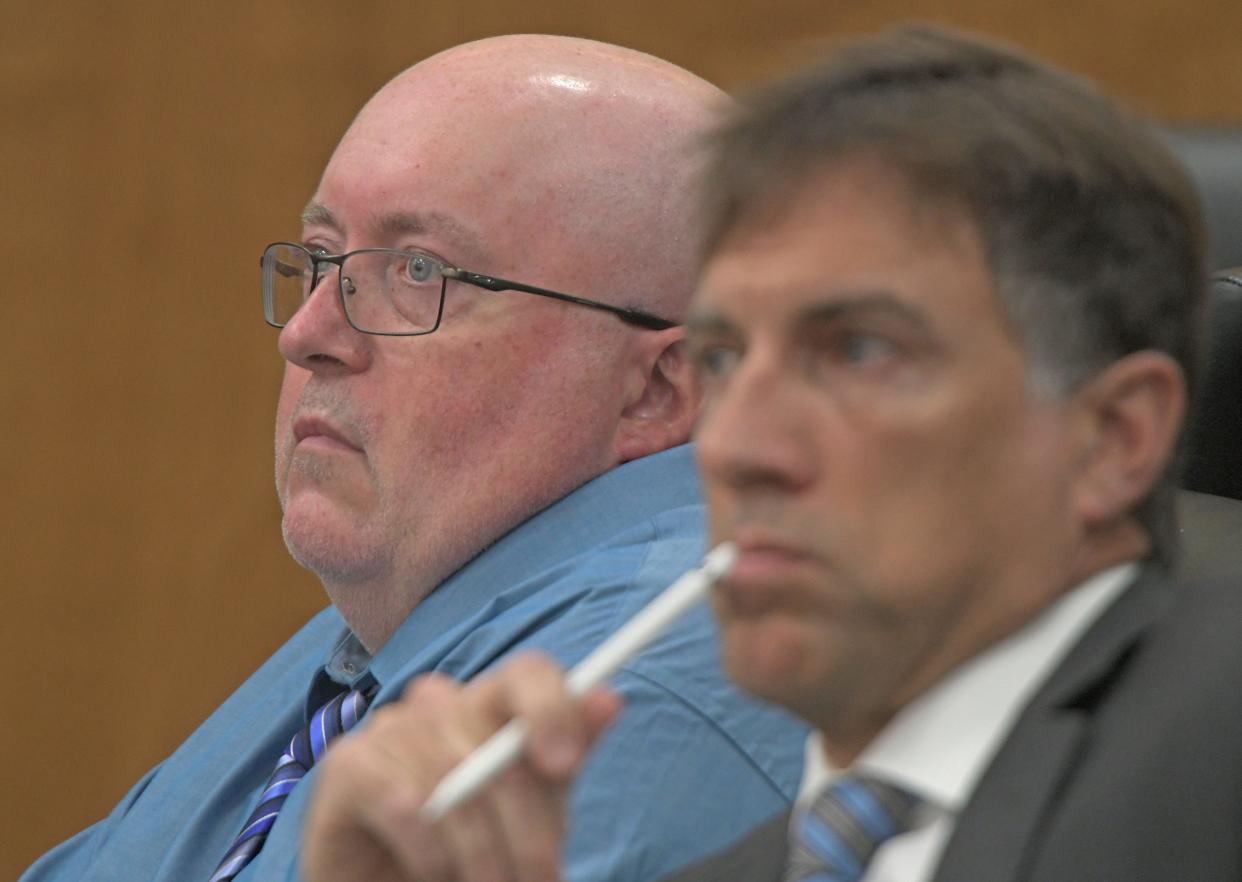 Mark Cooper, left, listens to opening statements with his attorney James Mayer III during his trial.