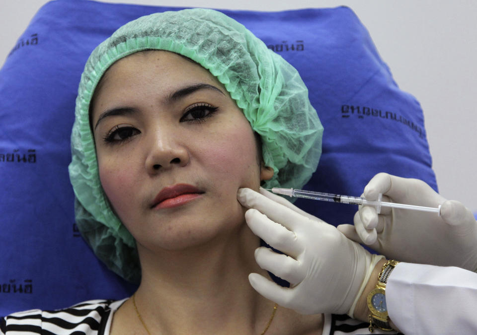 In this Oct. 17, 2012 photo, a 32-year-old Thai woman, Nisakron Boonpun gets a Botox injection at Bangkok's Yanhee Hospital, which houses one of the country’s best-known and largest beauty clinics. Bangkok has more than 500 licensed beauty clinics that cater to the wealthy but is also full of illegal, back-alley beauticians who are attracting young and working-class customers with rock-bottom prices. The recent case of a 33-year-old aspiring model who died from a botched collagen injection has drawn attention to the dark side of a booming beauty industry in Thailand. (AP Photo/Sakchai Lalit)