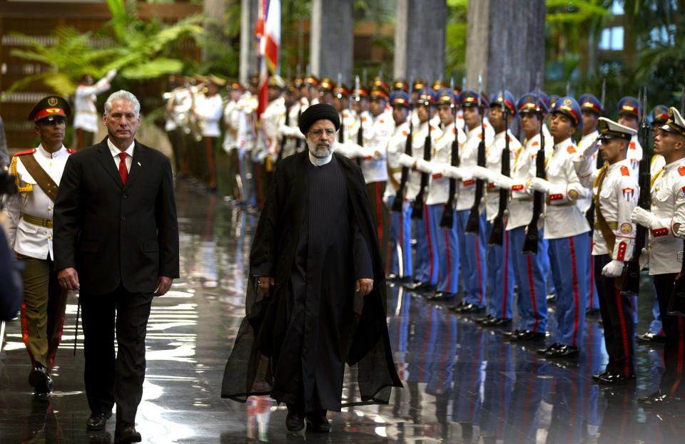 Cuban President Miguel Diaz-Canel, left, and Iran's President Ebrahim Raisi walk past the honor guard during a state visit in Havana, Cuba, Thursday, June 15, 2023. (AP Photo/Ismael Francisco)