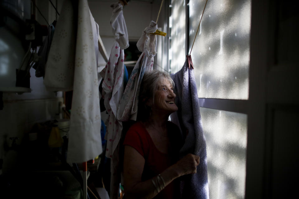 Carmela Corleto poses for a portrait amid her clothing that hangs to dry at home where she lives alone and waits her turn to get a COVID-19 vaccine in Burzaco, Argentina, Thursday, Feb. 18, 2021. Corelto, who said she didn't leave her house for seven months straight except to walk around the block after the lockdown started in March 2020, got her first shot of the AstraZeneca vaccine on April 23, 2021. (AP Photo/Natacha Pisarenko)