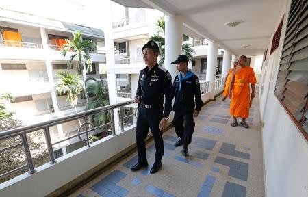 Policemen and Buddhist monks search for a fugitive Buddhist monk inside Dhammakaya temple in Pathum Thani province, Thailand February 17, 2017. REUTERS/Chaiwat Subprasom