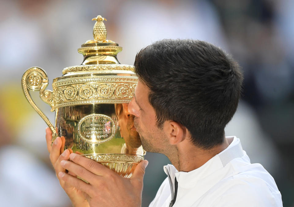 Tennis - Wimbledon - All England Lawn Tennis and Croquet Club, London, Britain - July 14, 2019  Serbia's Novak Djokovic poses with the trophy as he celebrates winning the final against Switzerland's Roger Federer  REUTERS/Toby Melville