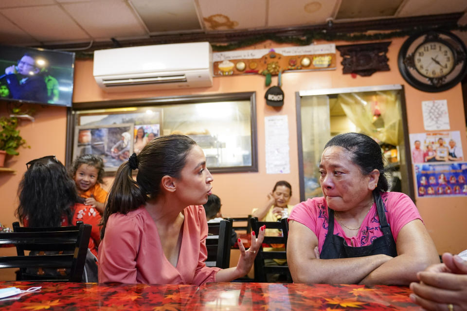 Rep. Alexandria Ocasio-Cortez, D-N.Y., left, talks to the owner of the Bhanchha Ghar restaurant Bimla Shrestha, Wednesday, July 6, 2022, in the Jackson Heights neighborhood of the Queens borough of New York. As she seeks a third term this year and navigates the implications of being celebrity in her own right, she's determined to avoid any suggestion that she is losing touch with her constituents. (AP Photo/Mary Altaffer)