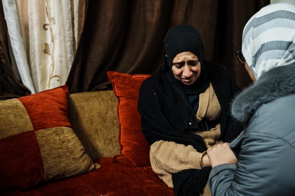 A woman is consoled while mourning the death of her two sons.