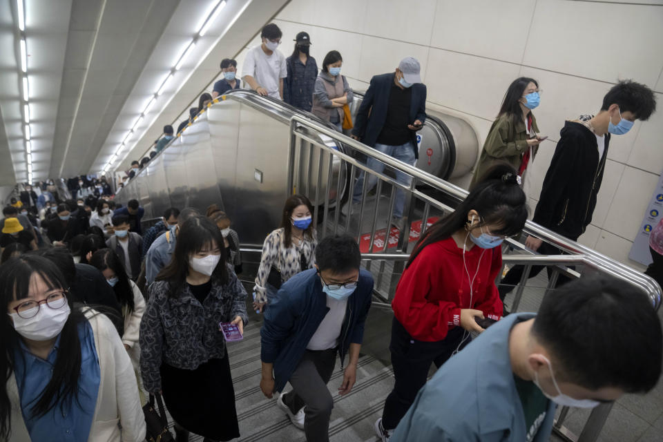 FILE - Commuters wearing face masks walk in a subway station in Beijing, Friday, April 22, 2022. Beijing is on alert after 10 middle school students tested positive for COVID-19 on Friday, in what city officials said was an initial round of testing. (AP Photo/Mark Schiefelbein, File)