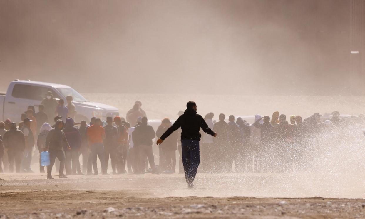 <span>Migrants near the border wall at Ciudad Juárez in Mexico.</span><span>Photograph: José Luis González/Reuters</span>