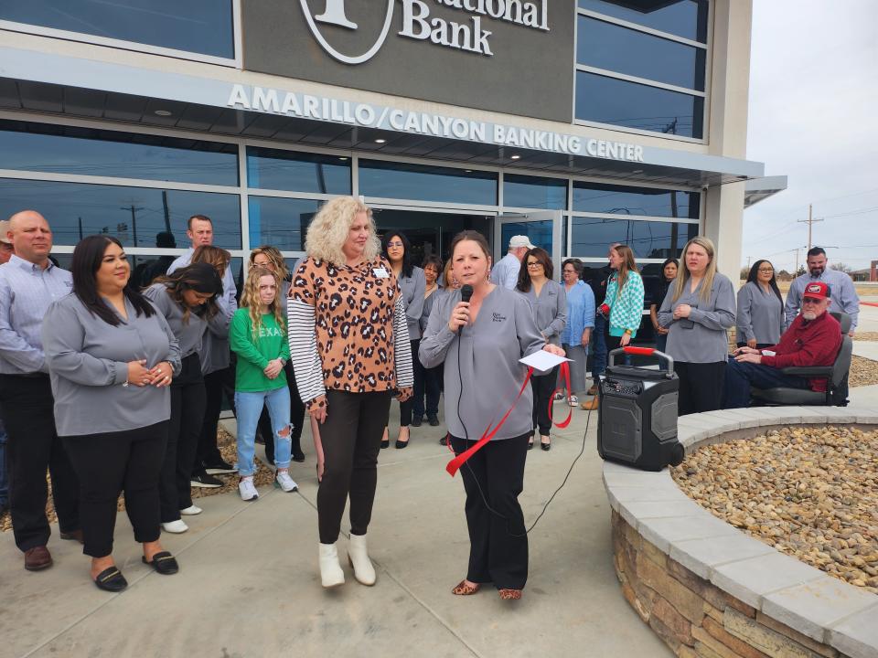 Kelly Norman, executive director of the Education Foundation of Canyon Independent School District, left, accepts a $5,000 donation from First National Bank of Amarillo/Canyon during its grand opening Thursday.