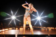 <p>During her second night of the tour, Swift surprised fans by wearing a completely different sparkling bodysuit. This look was covered in blue and gold jewels, with a matching chain necklace and Christian Louboutin knee-high boots. </p>