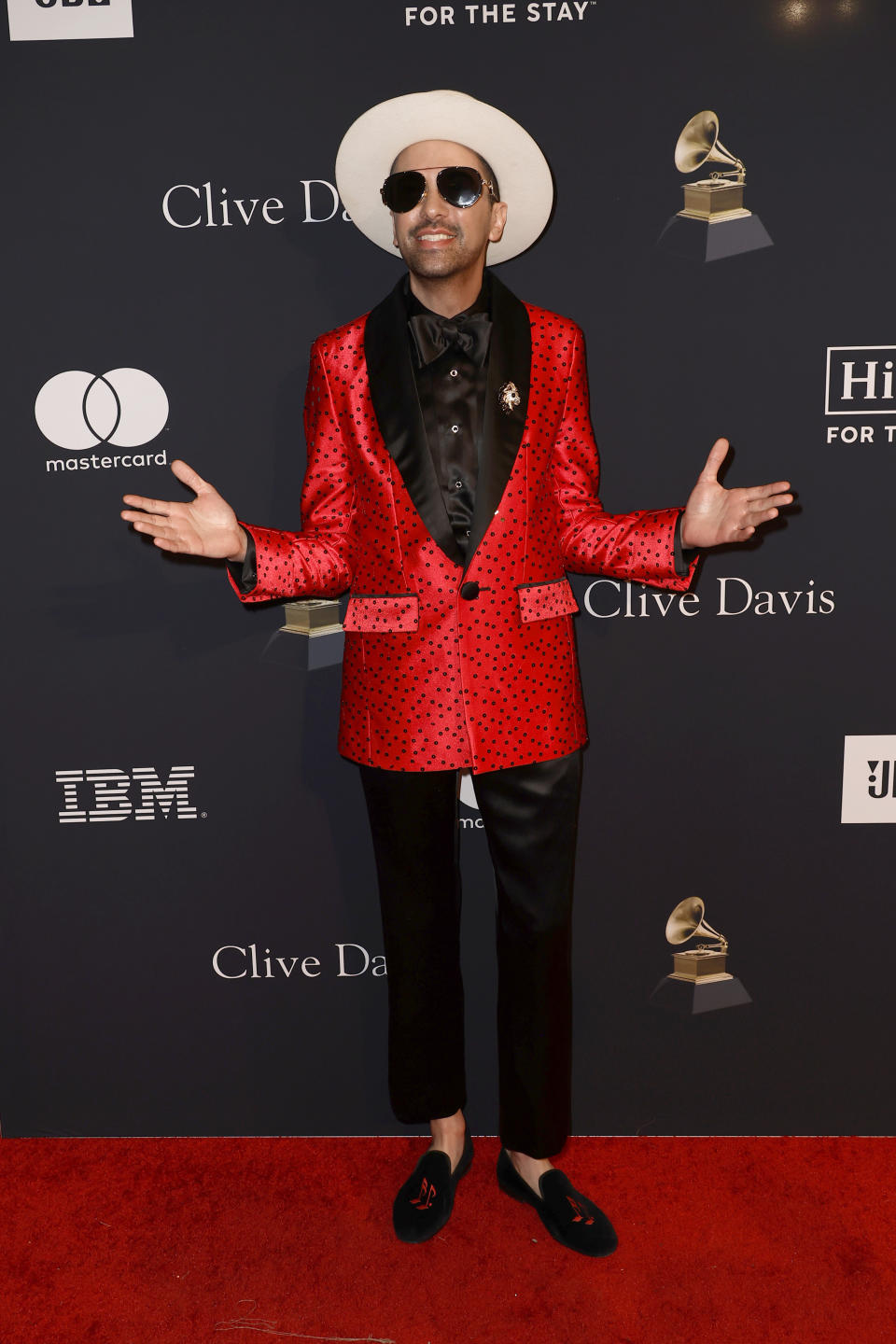 DJ Cassidy Wearing Red And Black Suit And Black Pants And Cream Hat