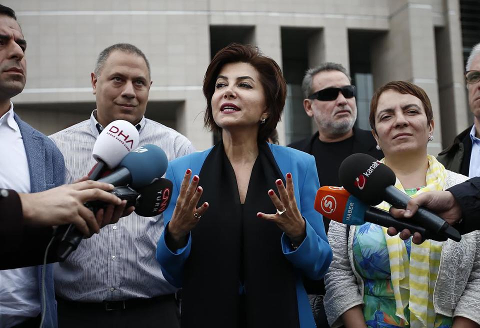 Turkish broadcast journalist Sedef Kabas (C), speaks to media members after her trial on October 6, 2015 in Istanbul. Sedef Kabas, a broadcast journalist and anchorwoman on the CNN-Turk channel, had been briefly detained in January for posting a tweet and faced up to five years in jail on charges of 