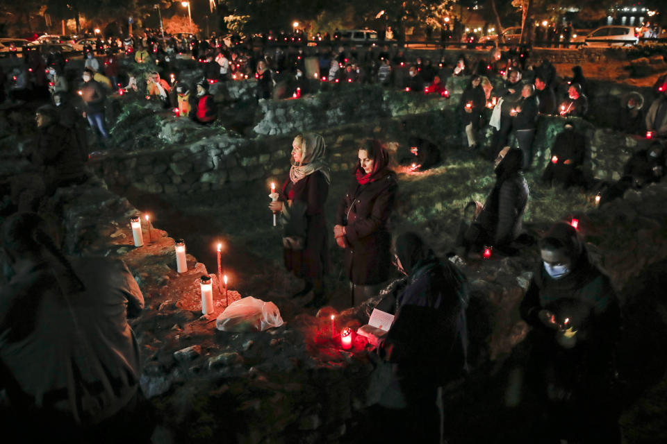 Orthodox worshipers, a few wearing masks for protection against the COVID-19 virus, spread around an open archaeological site outside the Cathedral of Saints Peter and Paul, which includes ruins dating as far back as the Roman Empire, hold candles during a religious service in the Black Sea port of Constanta, Romania, Wednesday, May 27, 2020. Romanian Orthodox Archbishop Teodosie rescheduled the Orthodox Easter service, which was to be held in mid-April, to offer worshippers an opportunity to celebrate Easter properly after the cancelling of the original April 19 service due to the national lockdown imposed because of the coronavirus pandemic. (AP Photo/Vadim Ghirda)