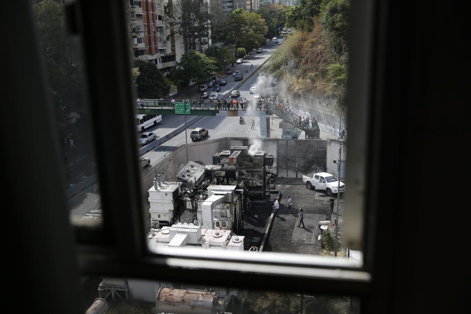 Transformers and electrical equipment smolder at electrical substation in the Baruta area of Caracas, Venezuela, Monday, March 11, 2019. An explosion rocked the power station early Monday, witnesses said, adding to the crisis created by days of nationwide power cuts. (AP Photo/Ariana Cubillos)