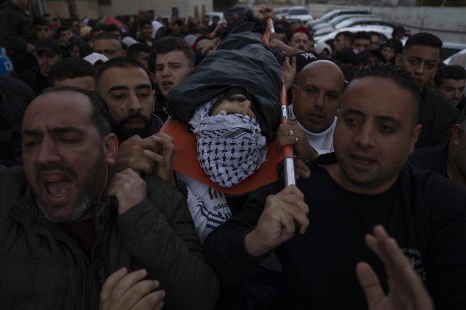 Mourners carry the bodies of Mohammad Abu Kushuk, 22, front, and Mohammad Herzallah, 30, during their funeral in the West Bank city of Nablus, Thursday, Nov. 24, 2022. The two Palestinians succumbed to their wounds sustained during clashes with Israeli army forces during military operations in the occupied West Bank. (AP Photo/Nasser Nasser)