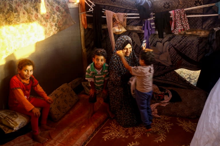 Noor and her children inside the family's shack near the beach in Gaza City