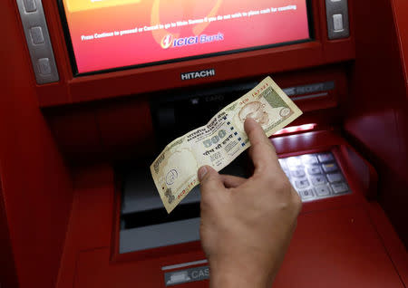 A customer deposits 500 Indian rupee banknote in a cash deposit machine in Mumbai, India, November 8, 2016. REUTERS/Danish Siddiqui