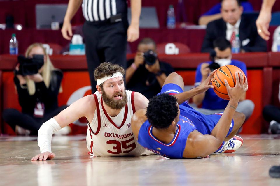 OU forward Tanner Groves (35) dives for a loose ball with Kansas forward David McCormack (33) during the first half Tuesday in Norman.