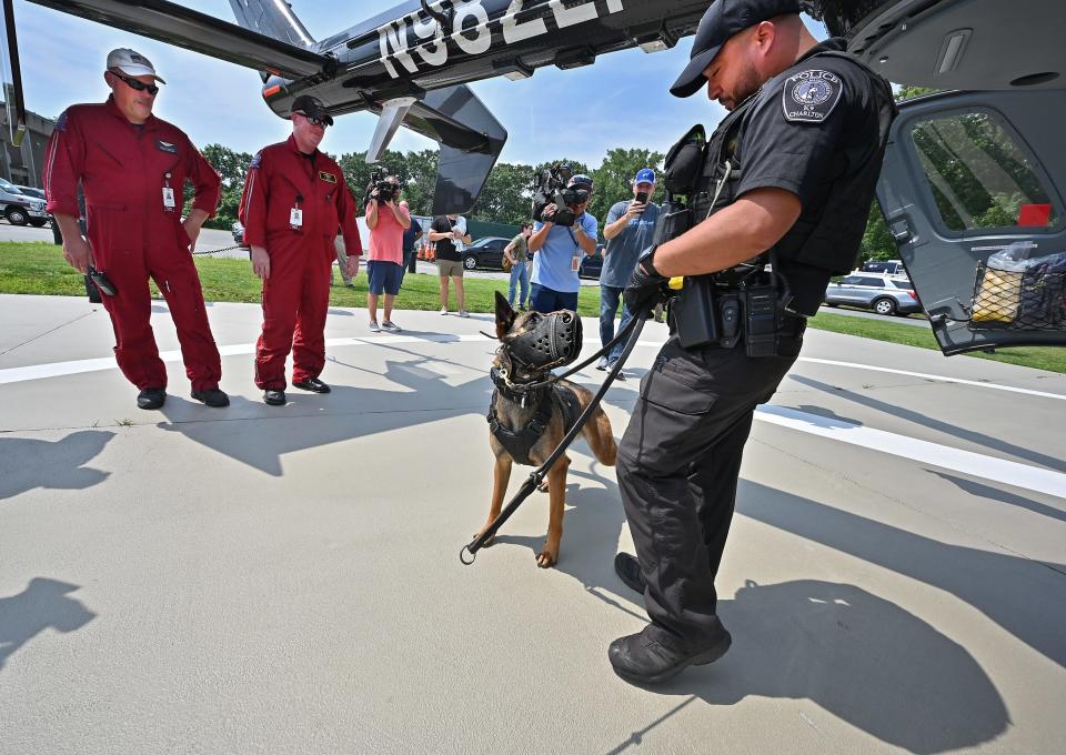 Charlton police Officer Derek Gaylord's K-9 partner Dozer looks to him for direction after taking part in a helicopter landing and K-9 air medical transport training exercise at Massachusetts State Police headquarters. Watching are UMass LifeFlight crewmembers EMT/paramedic Glenn Olson of North Smithfield, R.I., and pilot Edward Shoemaker of Millis.