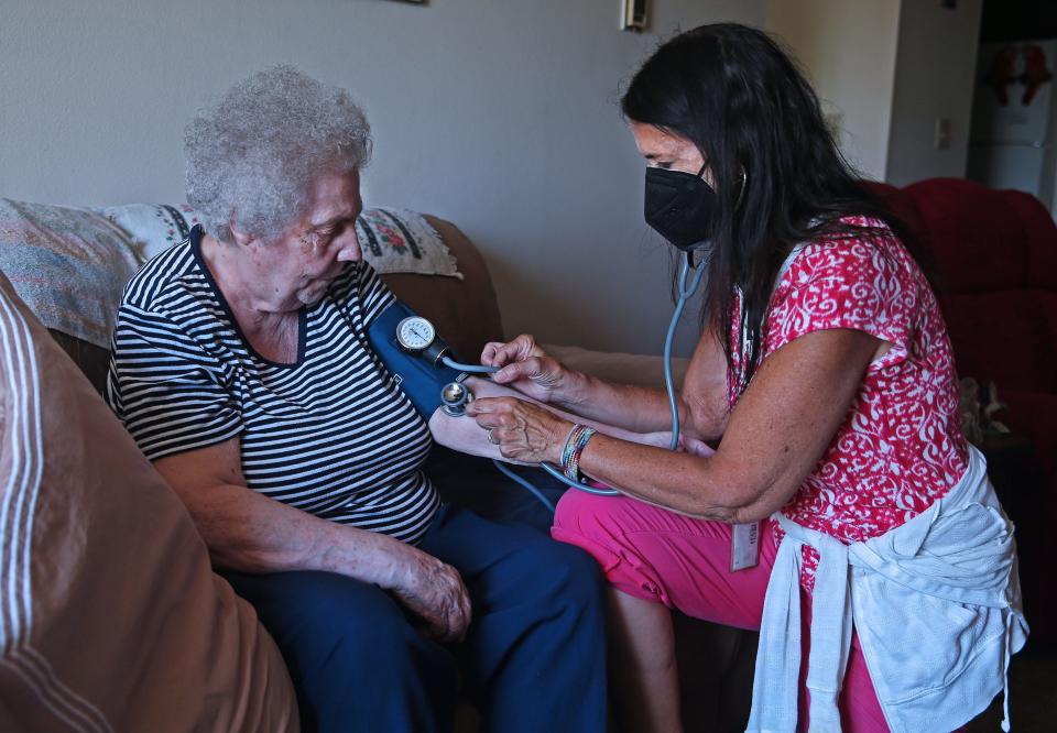 Ellen Tetting, left, has her blood pressure taken by Ascension All Saints - Family Health Center nurse Jenny Ovide during a home visit. Ovide has been meeting with Tetting for 15 years.