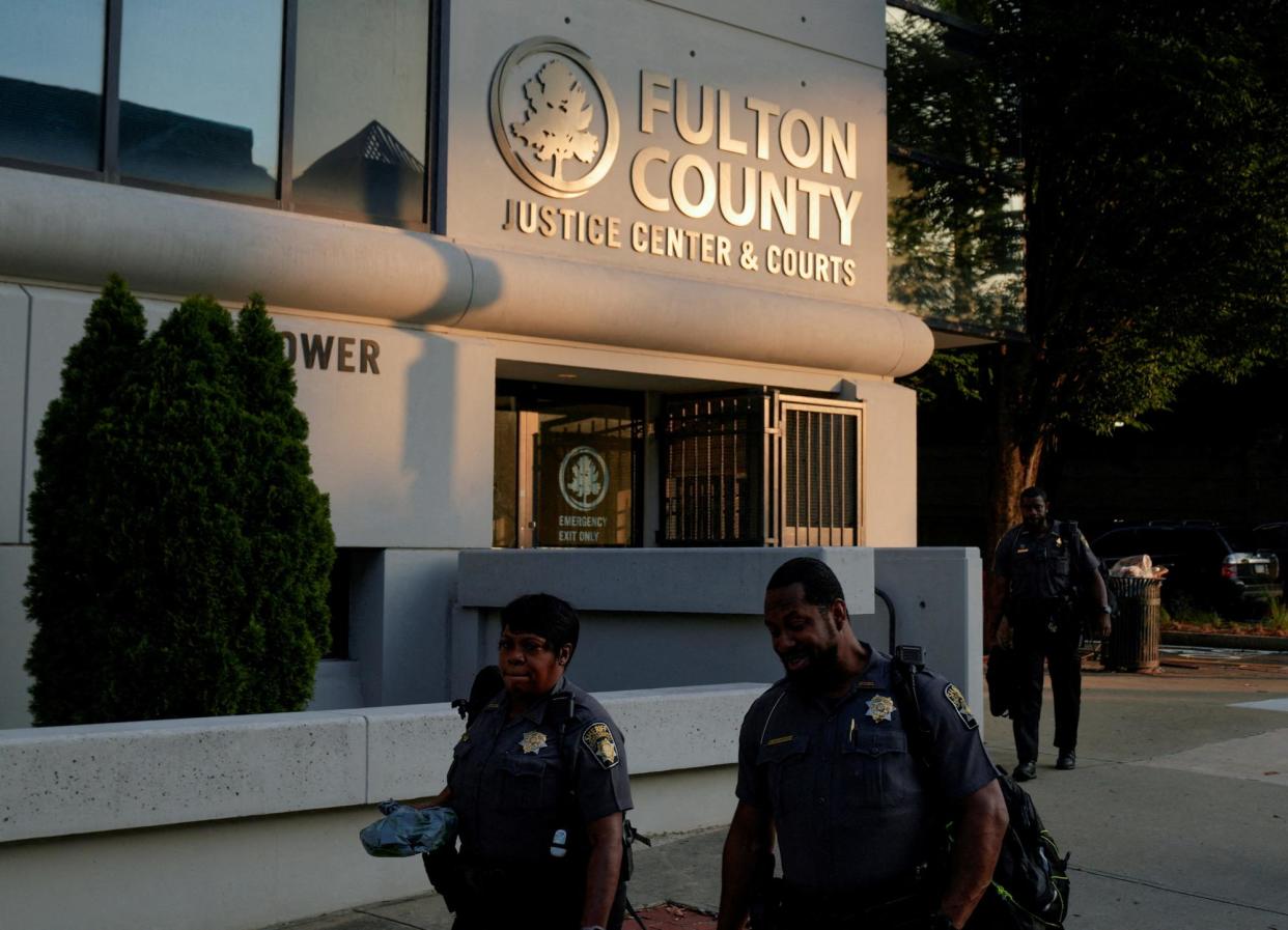 <span>Police officers walk past the Fulton county courthouse following the indictment of Donald Trump in Atlanta on 15 August 2023.</span><span>Photograph: Cheney Orr/Reuters</span>