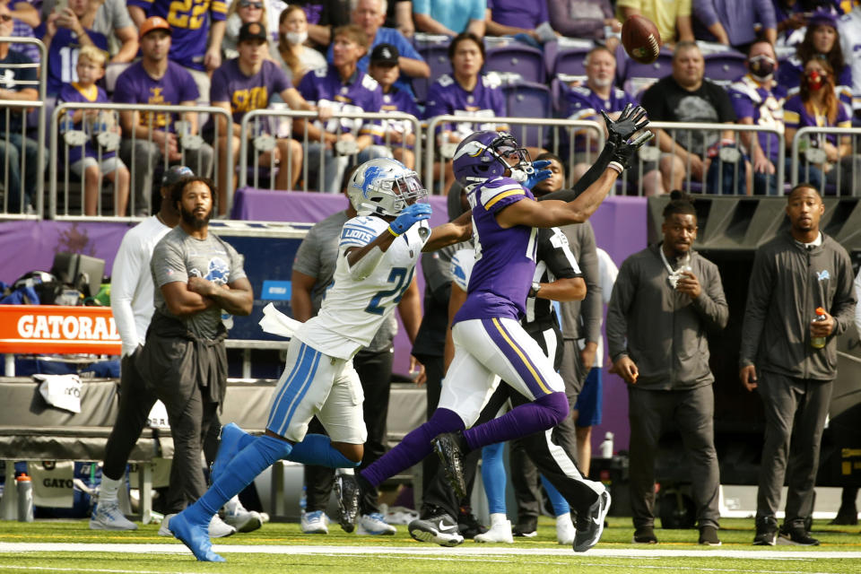 Minnesota Vikings wide receiver Justin Jefferson (18) catches a pass ahead of Detroit Lions cornerback Amani Oruwariye (24) during the first half of an NFL football game, Sunday, Oct. 10, 2021, in Minneapolis. (AP Photo/Bruce Kluckhohn)