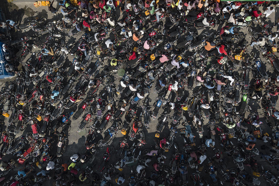 FILE - Motorcyclists gather at a gas station in hopes of filling their gas tanks, in Port-au-Prince, Haiti, Oct. 31, 2021, during a national fuel shortage which has kept aid agencies from operating at full capacity. (AP Photo/Matias Delacroix, File)