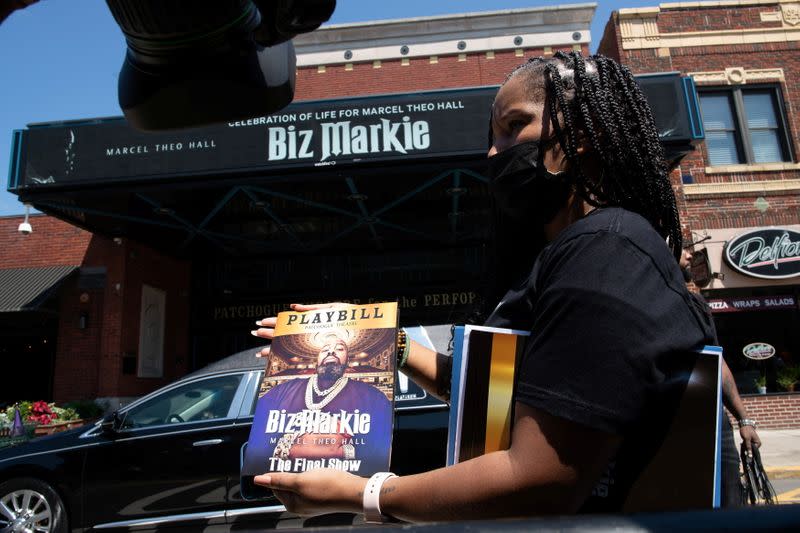 A woman displays the program during the funeral for late rapper Marcel Theo Hall, known by his stage name Biz Markie, outside Patchogue Theatre in Patchogue, New York