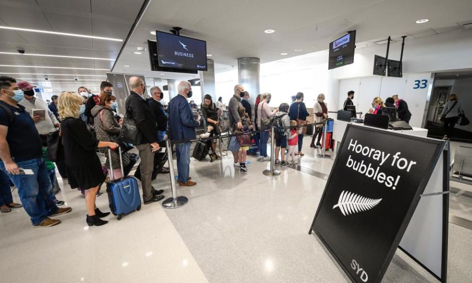 Passengers wearing face masks wait to board Qantas flight QF143 bound for Auckland at Sydney’s Kingsford Smith Airport