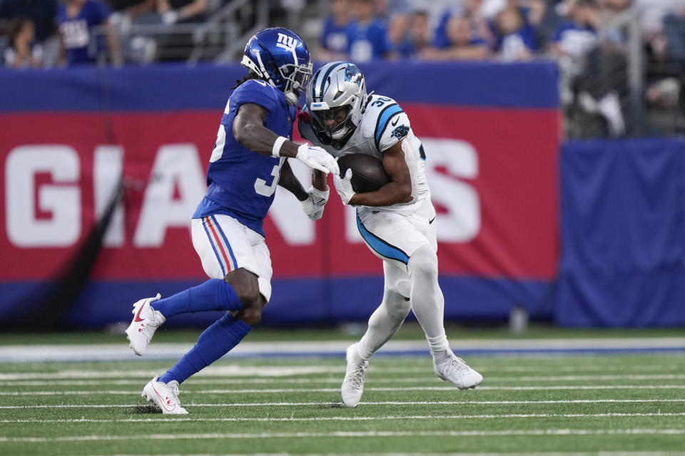 New York Giants' Deonte Banks, left, tries to defend Carolina Panthers' Chuba Hubbard during the first half of an NFL preseason football game, Friday, Aug. 18, 2023, in East Rutherford, N.J. (AP Photo/Bryan Woolston)