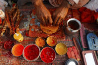 A Hindu priest prepares vermillion paste for pilgrims at Sangam during Magh mela festival, in Prayagraj, India. Friday, Feb. 19, 2021. Millions of people have joined a 45-day long Hindu bathing festival in this northern Indian city, where devotees take a holy dip at Sangam, the sacred confluence of the rivers Ganga, Yamuna and the mythical Saraswati. Here, they bathe on certain days considered to be auspicious in the belief that they be cleansed of all sins. (AP Photo/Rajesh Kumar Singh)