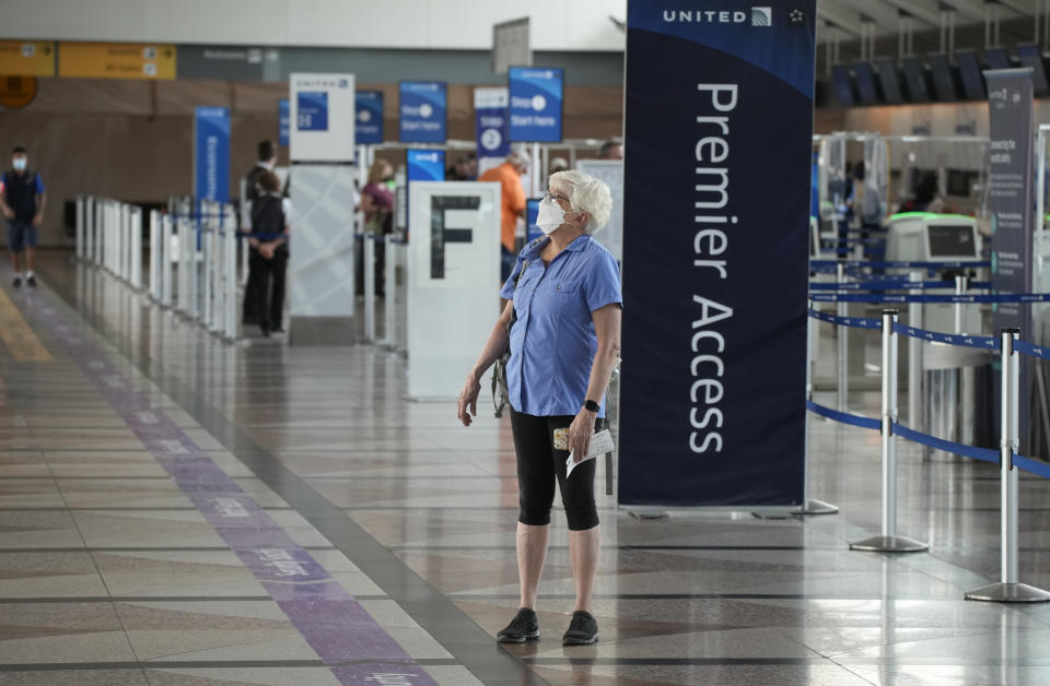 A lone traveler wears a face covering as she stops to check the departure monitors across from the United Airlines ticketing counter in the main terminal of Denver International Airport Tuesday, Aug. 24, 2021, in Denver. Two months after the Sept. 11, 2001 attacks, President George W. Bush signed legislation creating the Transportation Security Administration, a force of federal airport screeners that replaced the private companies that airlines were hiring to handle security. (AP Photo/David Zalubowski)