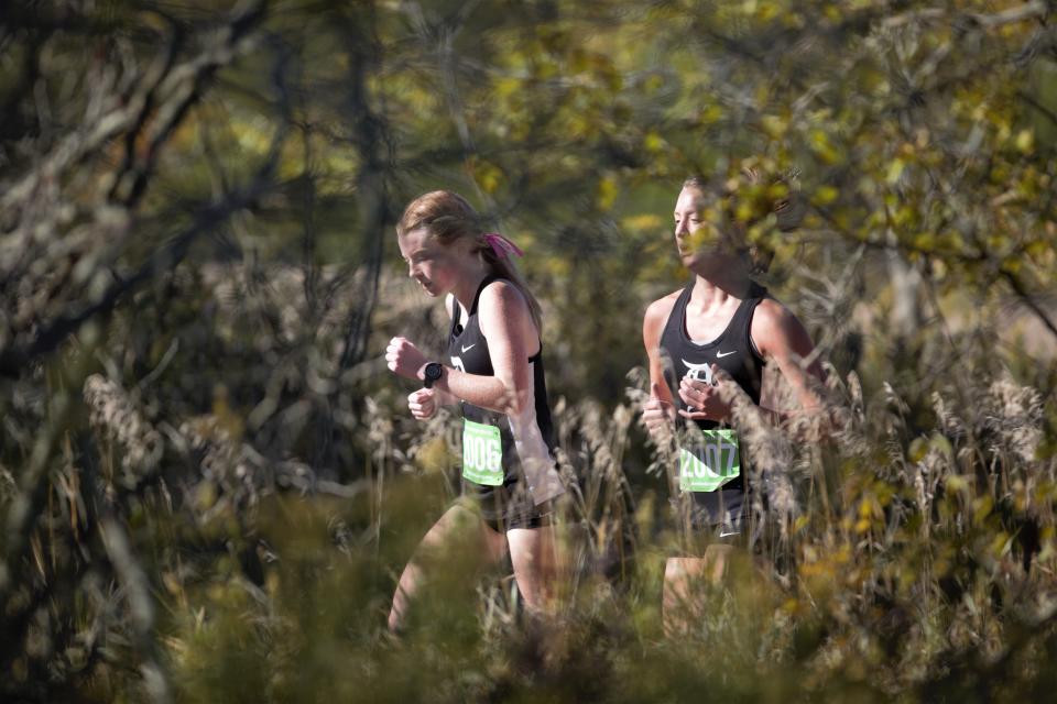 Daleville's Kadence Aikin (left) and Jenna Brand (right) run during the Delta cross-country sectional at Taylor University Saturday, Oct. 8, 2022.