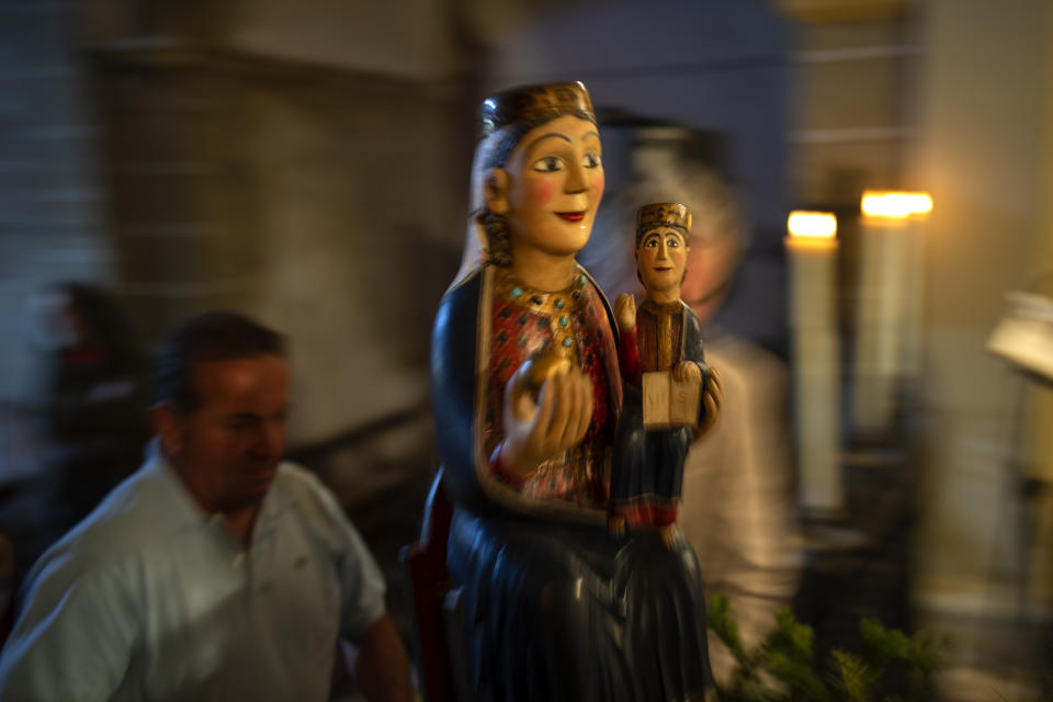 Local residents take part in a procession carrying a statue of the Our Lady of the Torrents, a virgin historically associated with drought, in l'Espunyola, north of Barcelona, Spain, Sunday, March 26, 2023. Farmers and parishioners gathered Sunday at the small hermitage of l'Espunyola, a rural village in Catalonia, to attend a mass asking the local virgin Our Lady of the Torrents for rain. Prayers and hymns were offered to ask for divine intervention in solving the earthly crisis. (AP Photo/Emilio Morenatti)