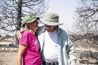 Robert Wise hugs on Monday, Sept. 21, 2020 his neighbor Cheryl Poindexter, who lost her home of 27 in the Bobcat fire. Poindexter ran an animal rescue on her 11 acres along Juniper Hills Road. (Sarah Reingewirtz/The Orange County Register via AP)