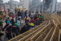 Protesting farmers break police barricades as they march to the capital during India's Republic Day celebrations in New Delhi, India, Tuesday, Jan. 26, 2021. Tens of thousands of farmers drove a convoy of tractors into the Indian capital as the nation celebrated Republic Day on Tuesday in the backdrop of agricultural protests that have grown into a rebellion and rattled the government. (AP Photo/Altaf Qadri)