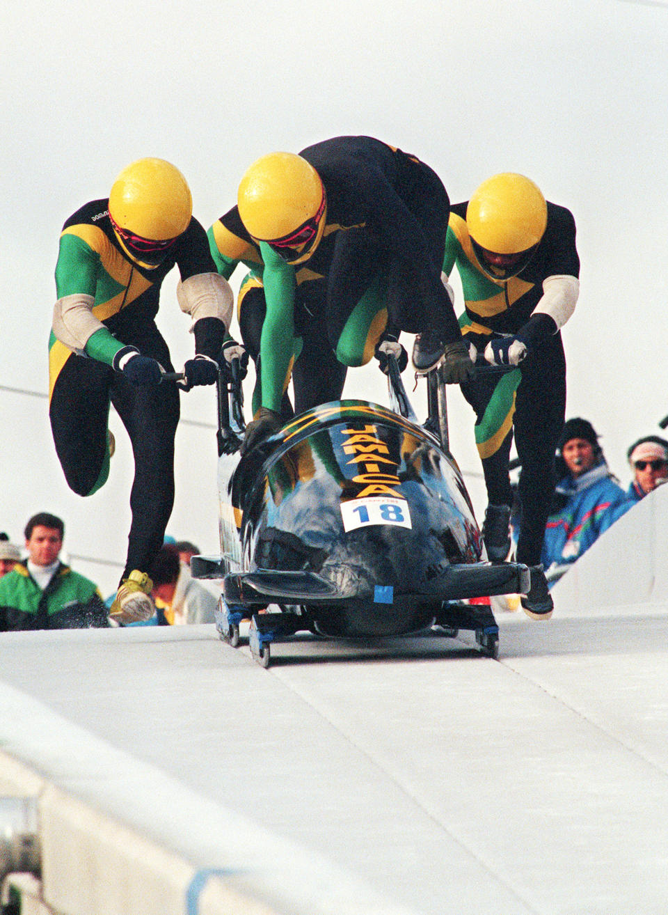 <p>Jamaican pilot Dudley Stokes jumps in as his three teammates push off at the start of the second run of the Olympic four-man bobsled event at the Calgary Olympics in 1988. (Getty Images) </p>