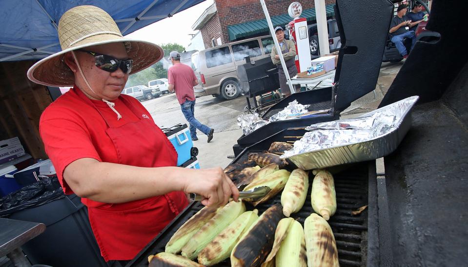 Tammy Siharath turns corn on a grill during the Cherry Blossom Festival on Main Street in Cherryville Saturday, April 22, 2023.