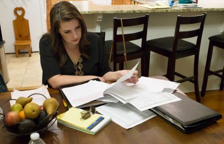 Sarah Kline reviews mold inspection and maintenance paperwork in her home at the U.S. Military Academy in West Point, New York, U.S March 26, 2019. After the inspection confirmed mold and water damage, the military is now withholding the rent it pays on her house from her landlord, pending repairs. REUTERS/Andrea Januta