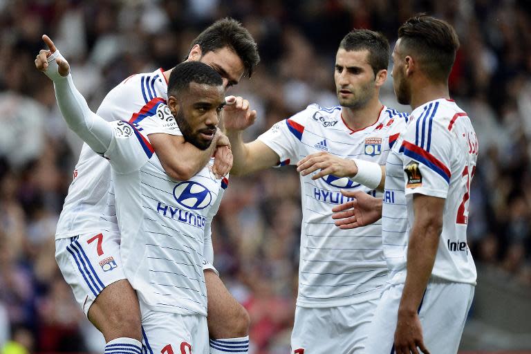 Lyon's forward Alexandre Lacazette (L) celebrates with teammtes after scoring a goal during their French Ligue 1 match against Evian, at the Gerland Stadium in Lyon, central eastern France, on May 2, 2015