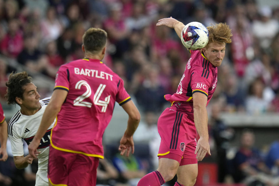 St. Louis City's Tim Parker, right, heads the ball toward teammate Lucas Bartlett (24) as Vancouver Whitecaps' Simon Becher, left, watches during the first half of an MLS soccer match Saturday, May 27, 2023, in St. Louis. (AP Photo/Jeff Roberson)