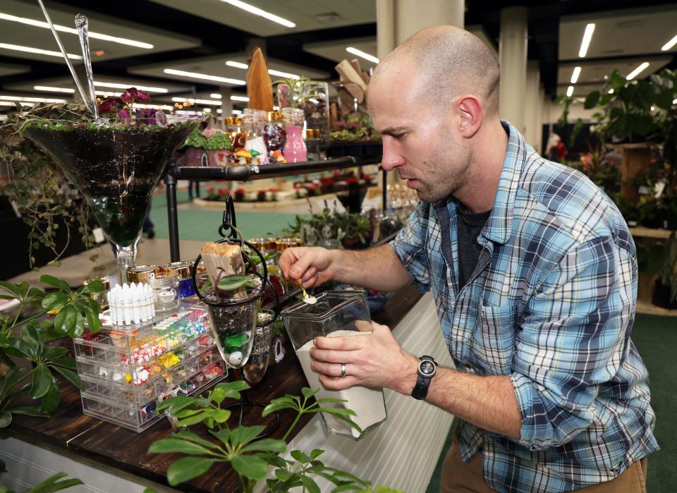 Tom Foote of Art Terrarium works on another creation at the 46th annual Des Moines Home + Garden Show at the Iowa Events Center in Des Moines on Friday, Feb. 23, 2024.